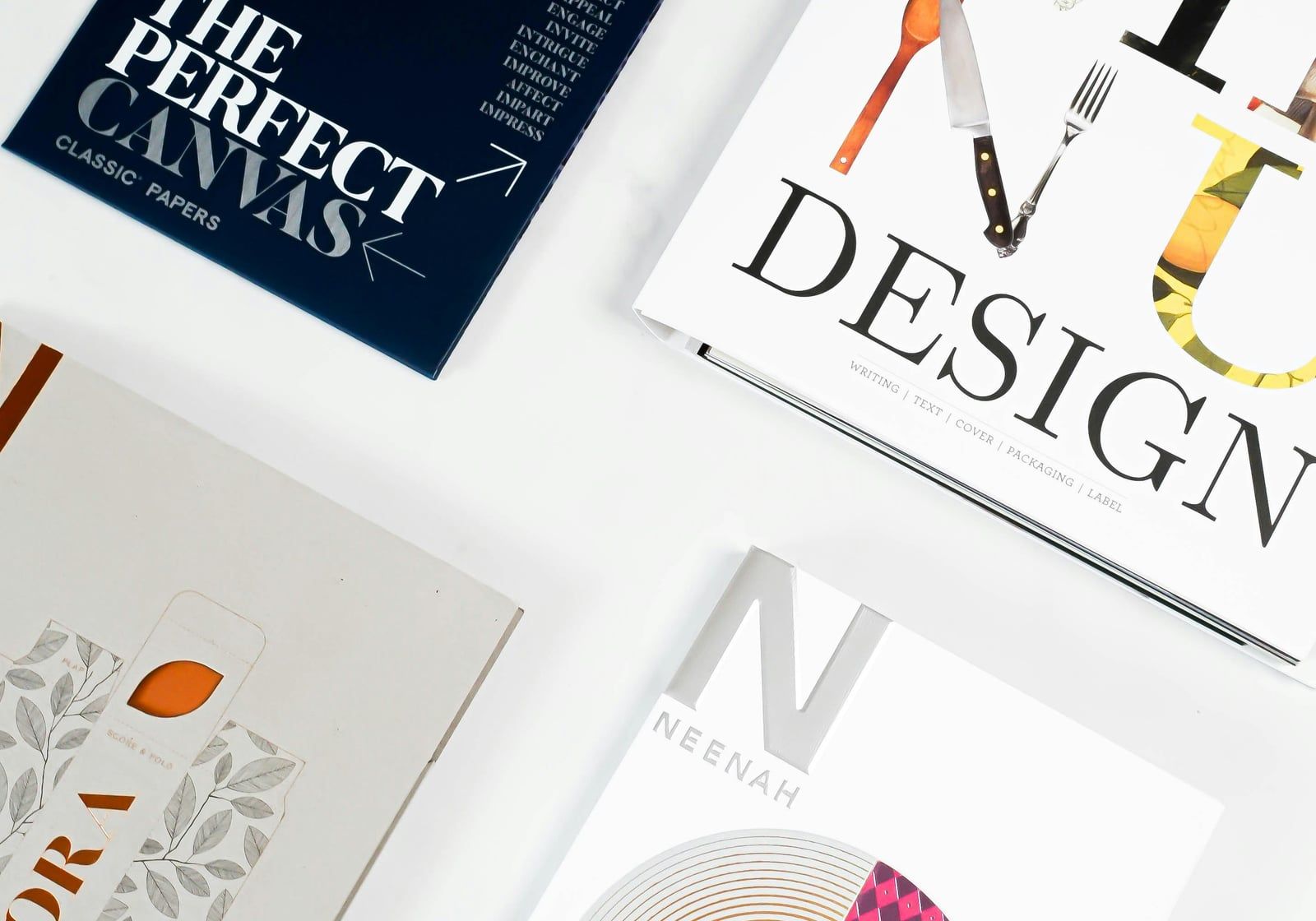 Printed design brochures and paper samples on a white surface