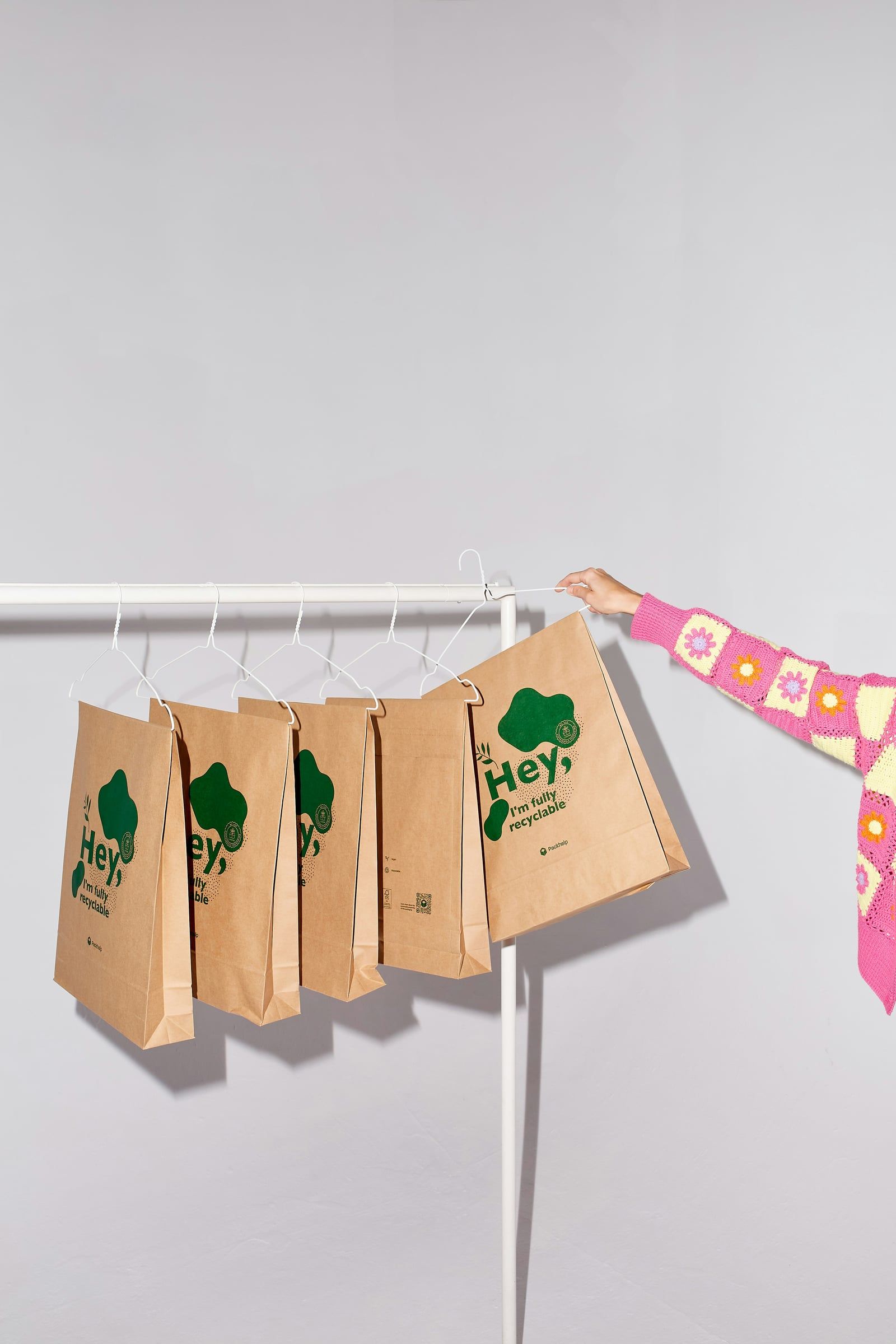 Recyclable paper bags hanging from a clothes rail